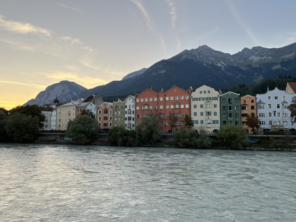 View of colorful buildings in Innsbruck and river with sunset