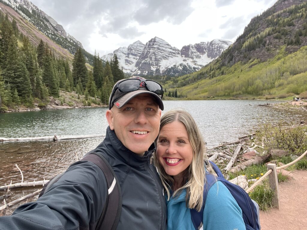 Couple in front of snowcapped mountains, lake