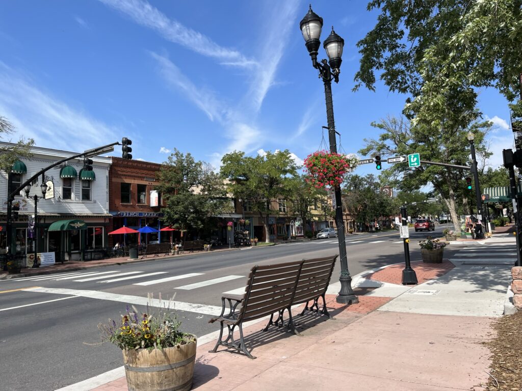 Old Colorado City shows buildings, flowers, street lights and park benches